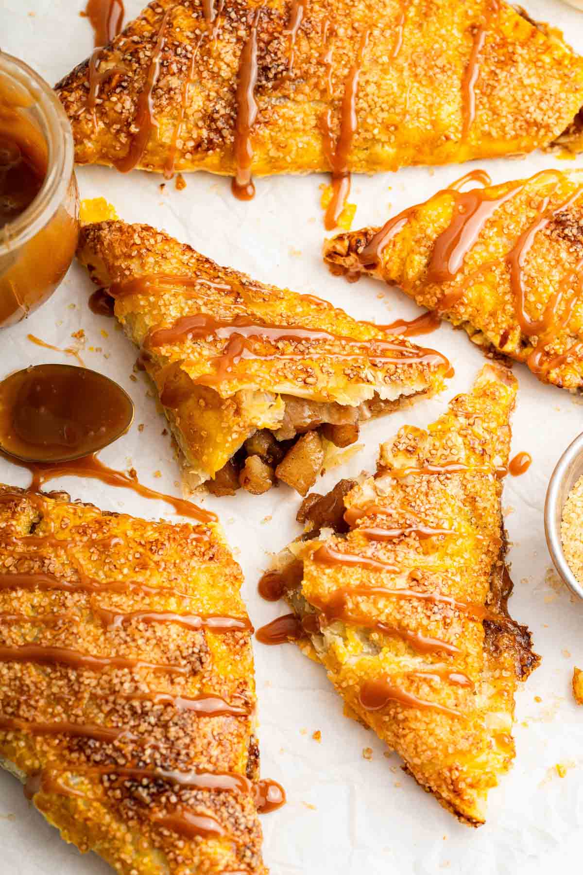 Triangle apple turnovers made with puff pastry and drizzled with caramel.