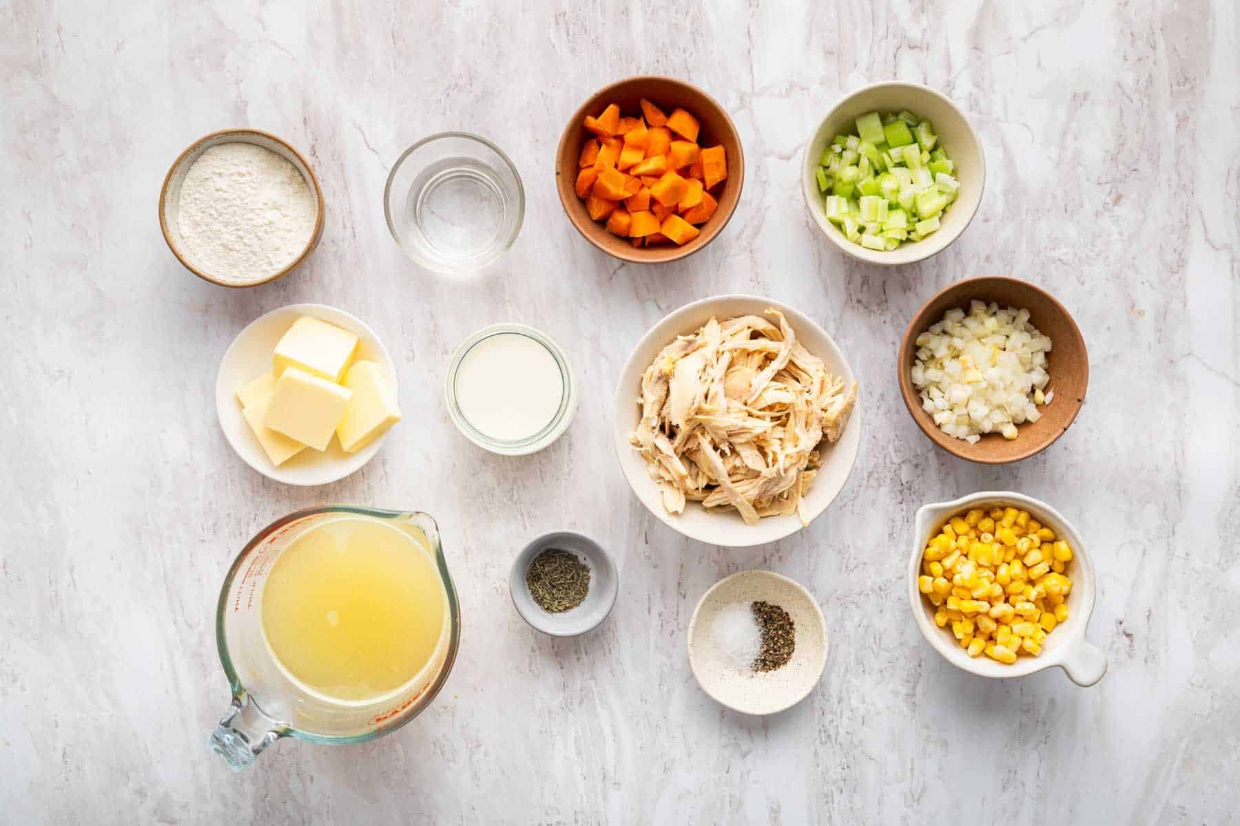 Small bowls of shredded meat, diced veggies, and spices on a kitchen counter.