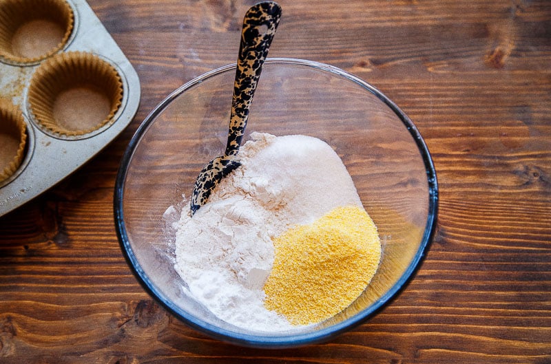Clear bowl with flour, sugar, and cornmeal in it.