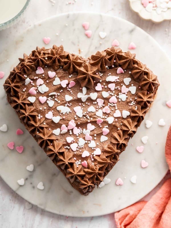 Vertical image of chocolate heart cake with sprinkles on top.