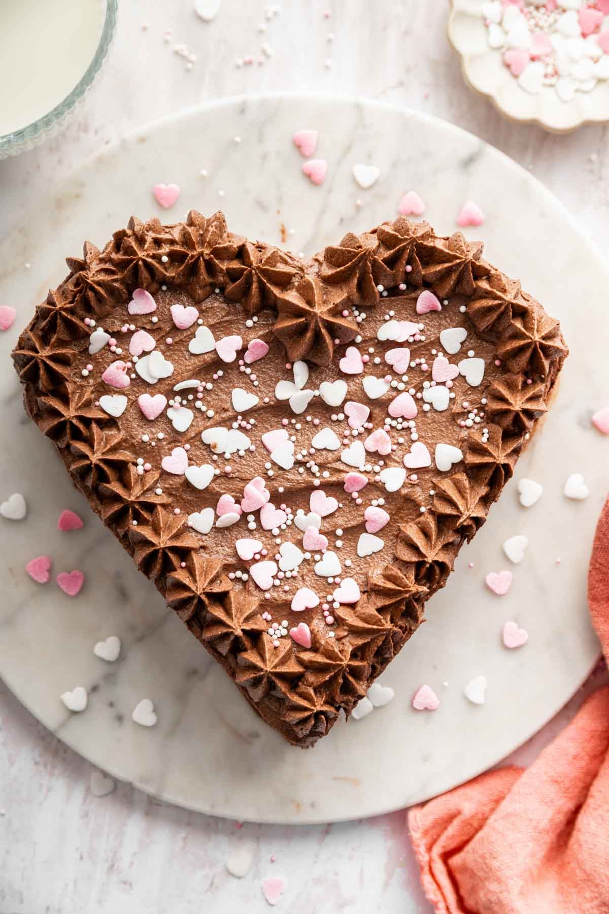 Vertical image of chocolate heart cake with sprinkles on top.