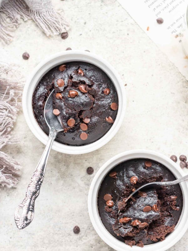 Two ramekins of microwave brownie pots with spoons.