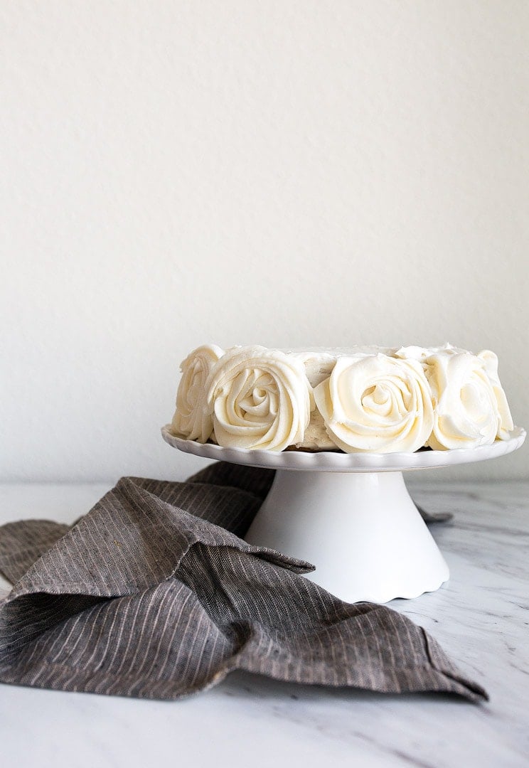 Mini Vanilla Cake for Two people in a 6" small round cake pan. Vanilla buttercream roses on the sides.