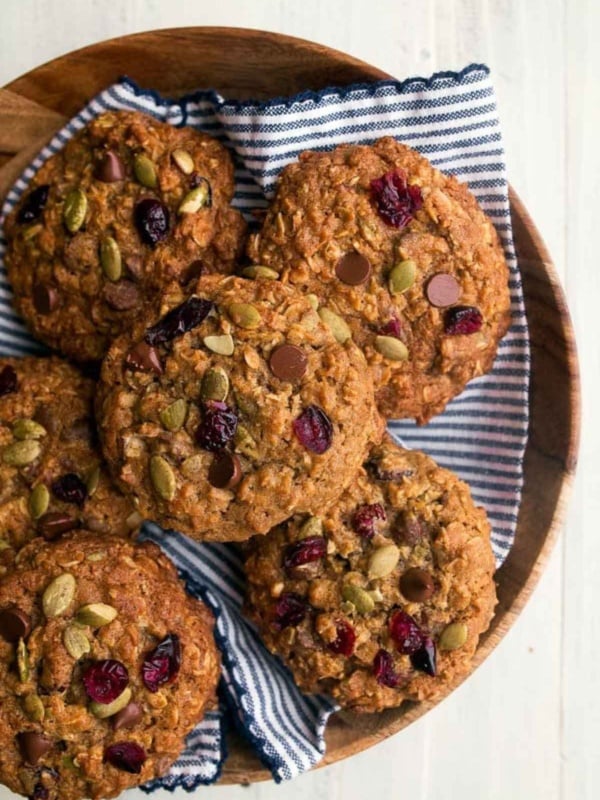 Overheat shot of pumpkin spice oatmeal cookies in wooden bowl with blue striped napkin.