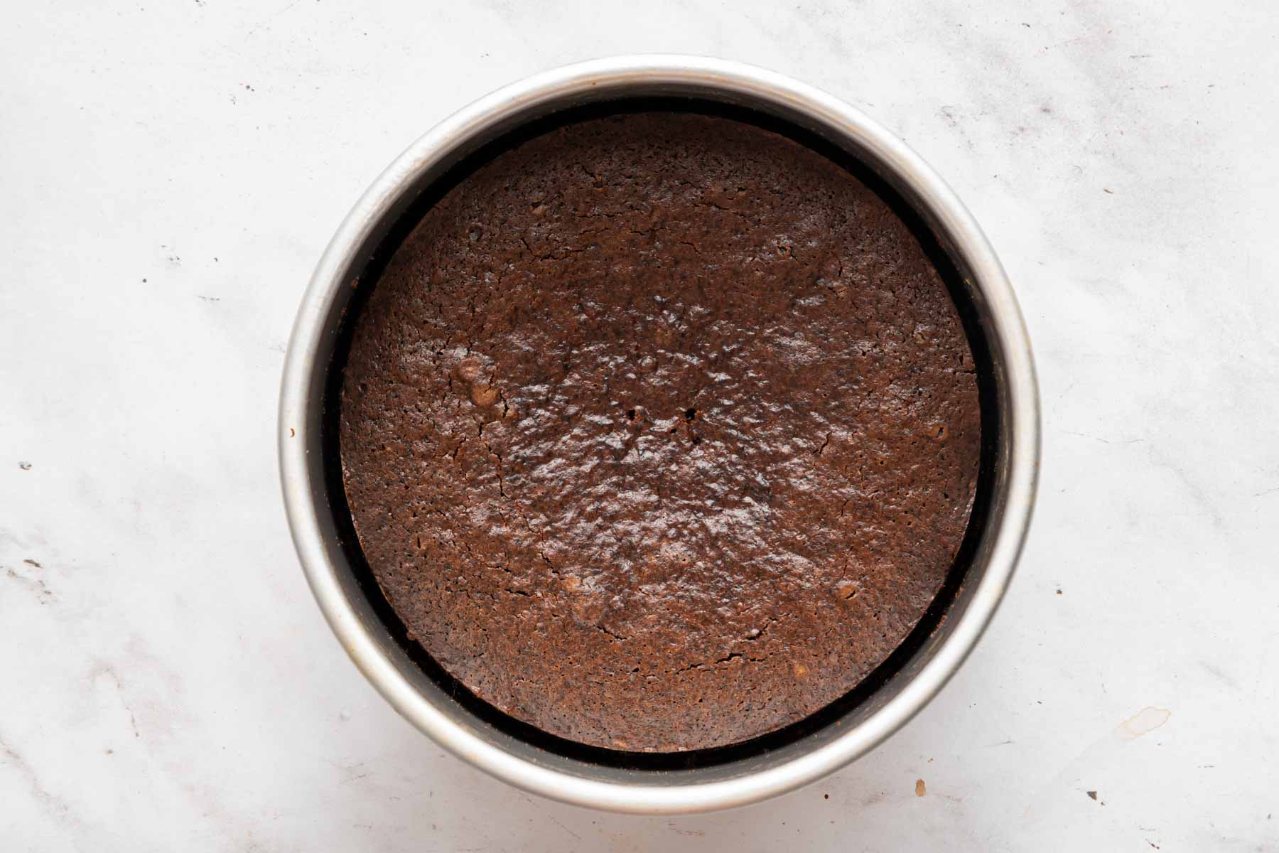 Freshly baked cake in a round pan.