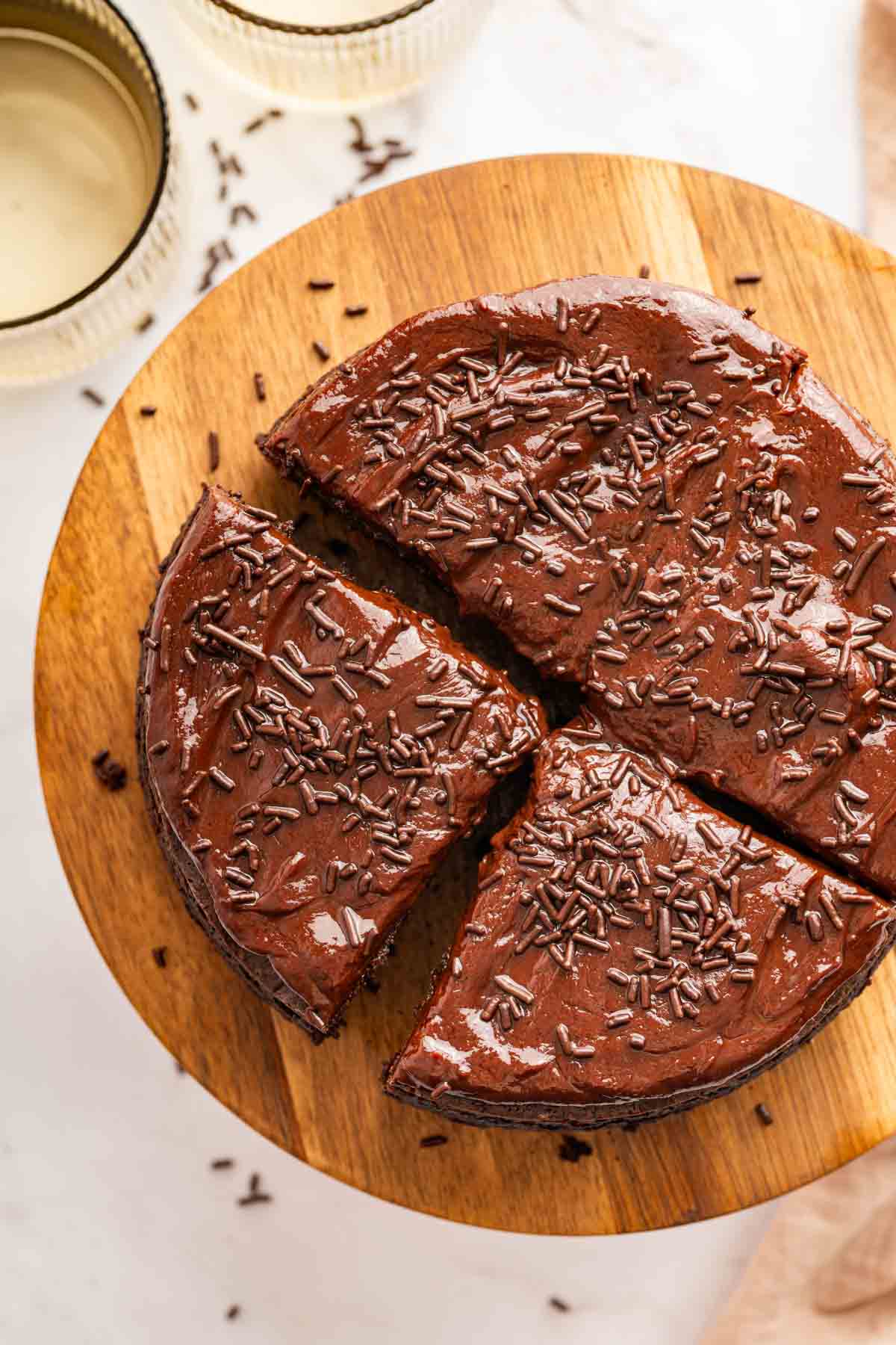 Overhead image of small sour cream chocolate cake cut into 4 pieces.