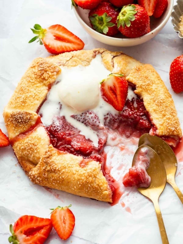 Strawberry galette with a scoop of melting ice cream on top.