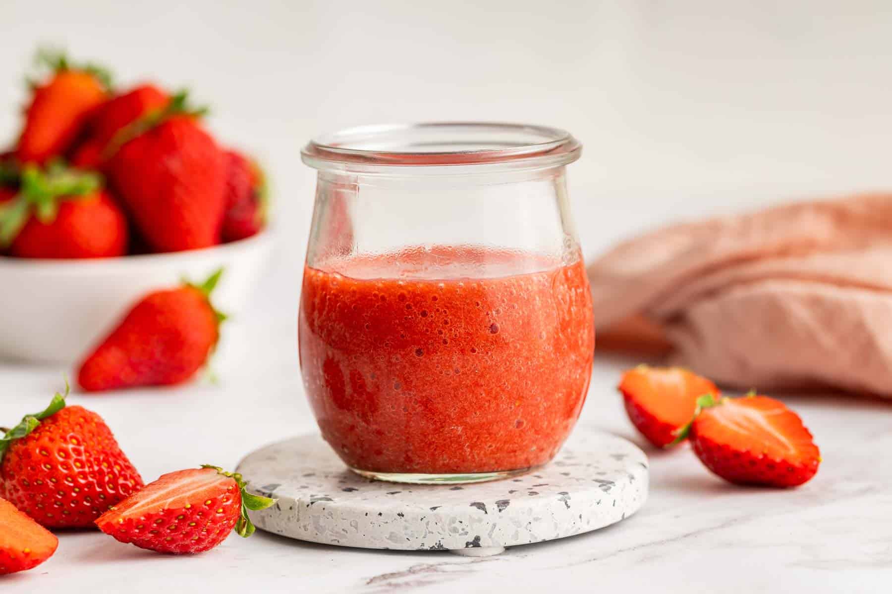 Small week jar with fresh strawberry sauce in it.