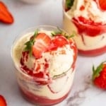 Two glass mugs full of a strawberry sundae.
