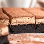 Tiramisu brownies cut from the side showing the rich brownie layer, fluffy top and cocoa powder dust.