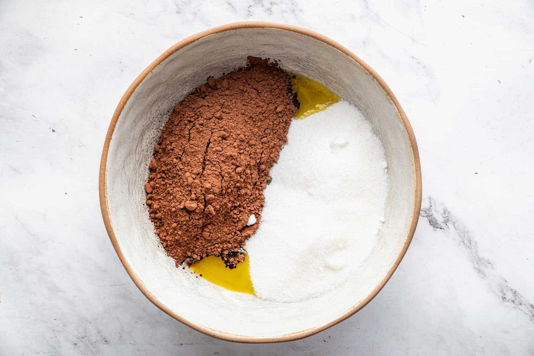 Bowl with cocoa powder, granulated sugar, and melted butter underneath.