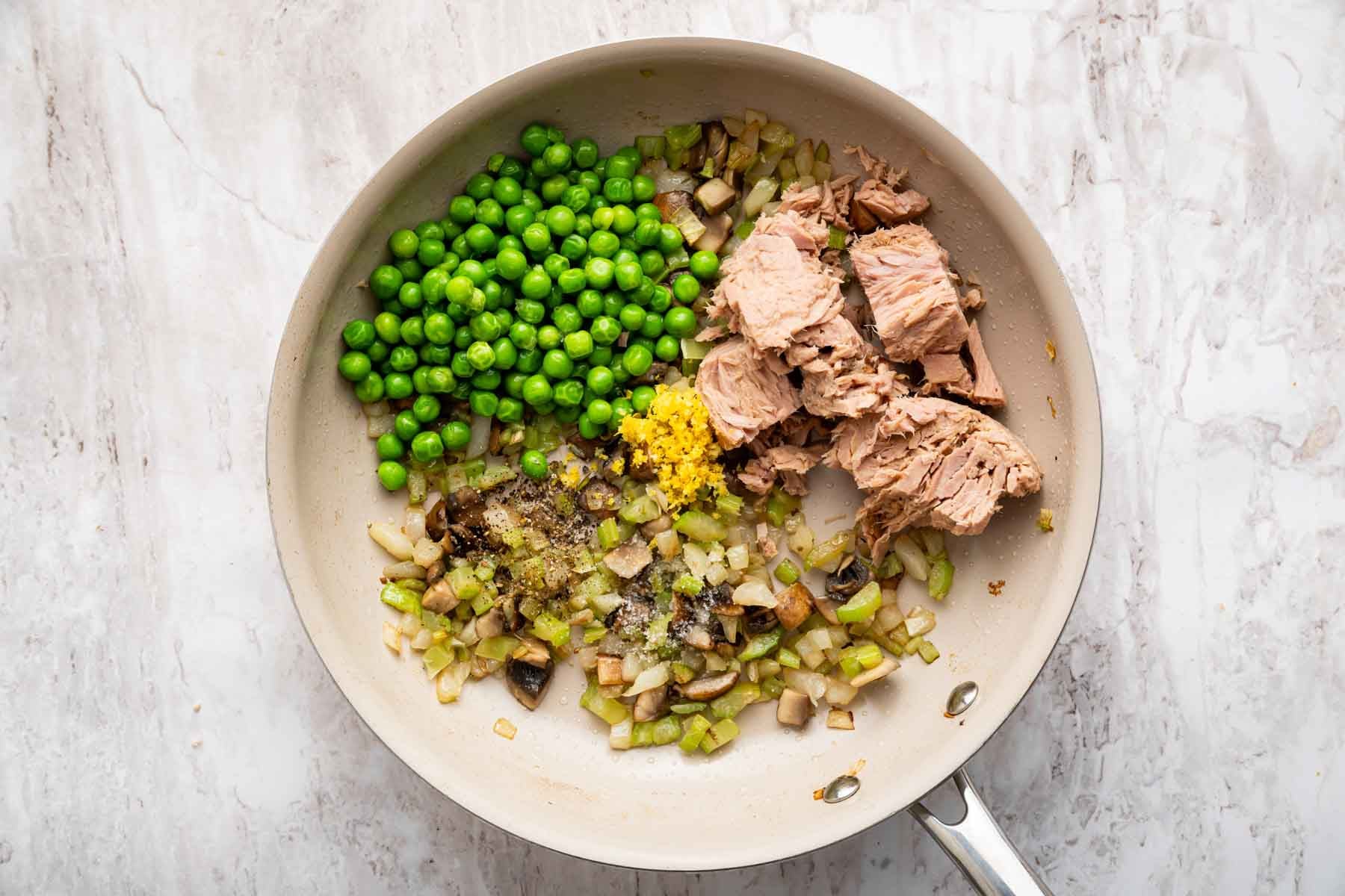Fresh chopped veggies and chunks of tuna in a saute pan.