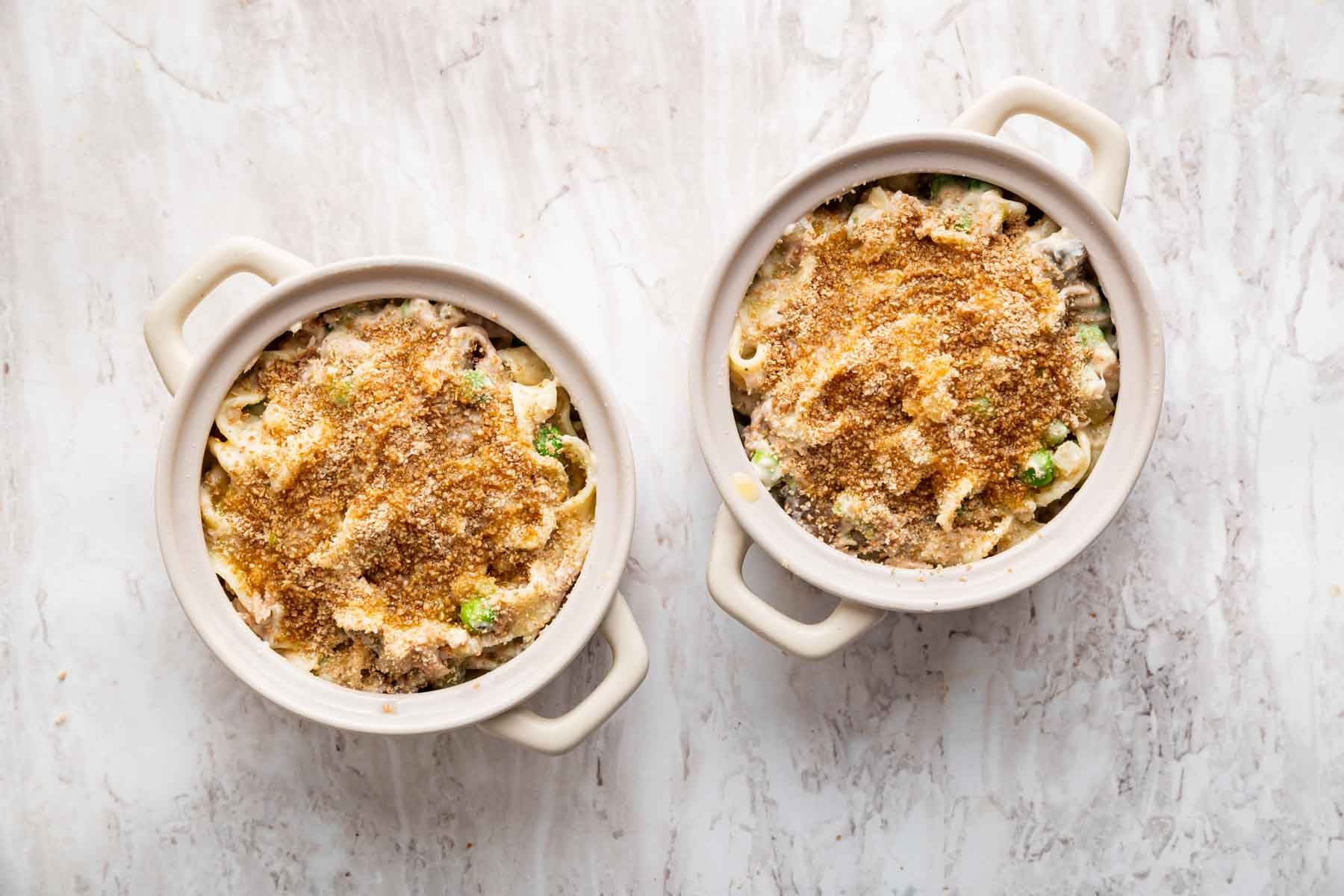 Two small casserole dishes topped with breadcrumbs, before baking.