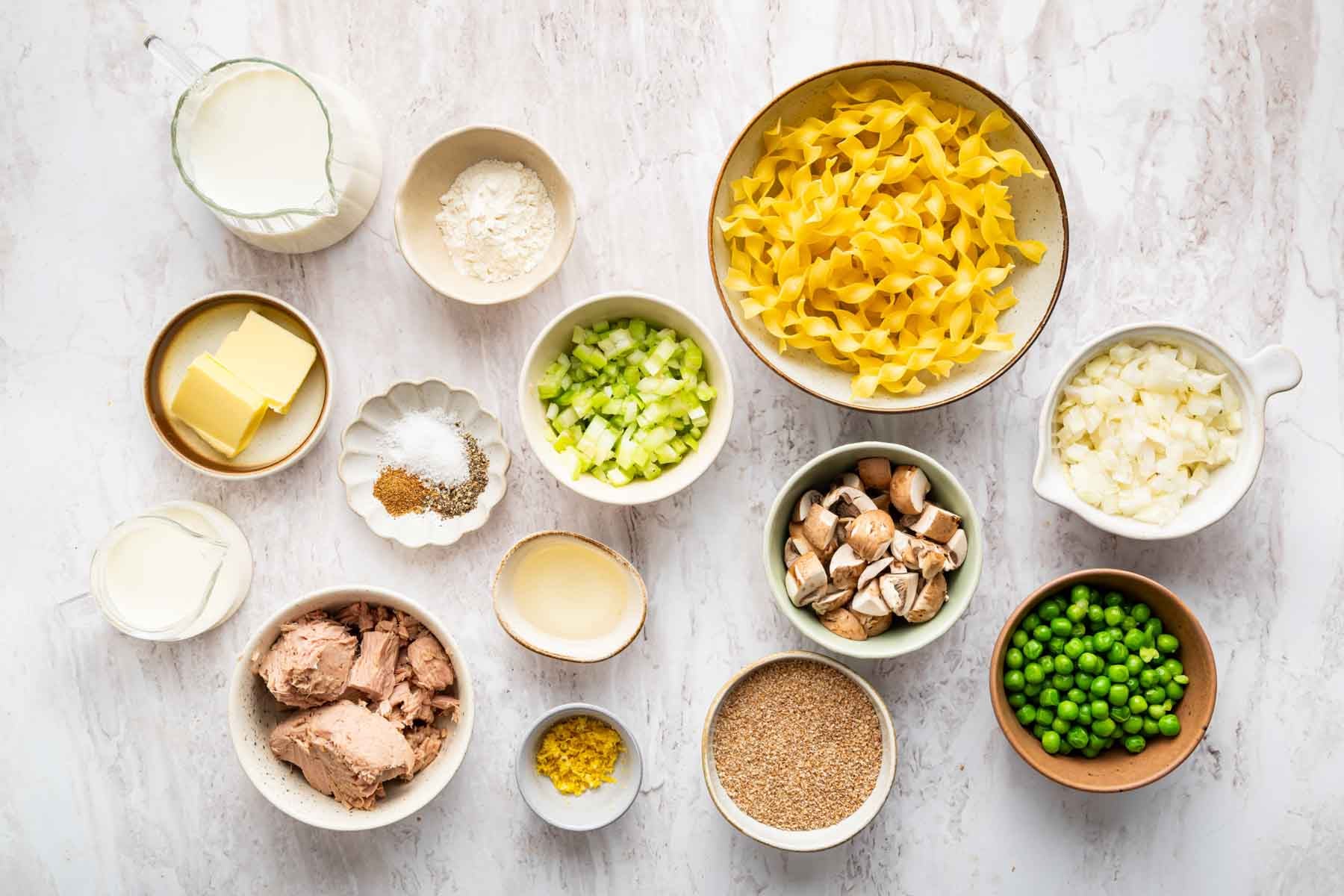 Small bowls with pasta, chopped veggies, and herbs.