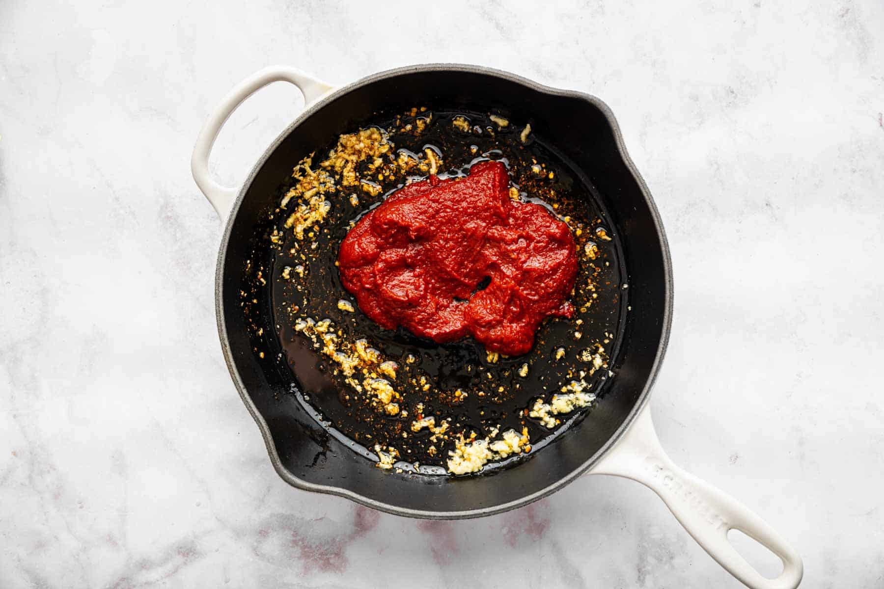 Clump of tomato paste in black skillet.